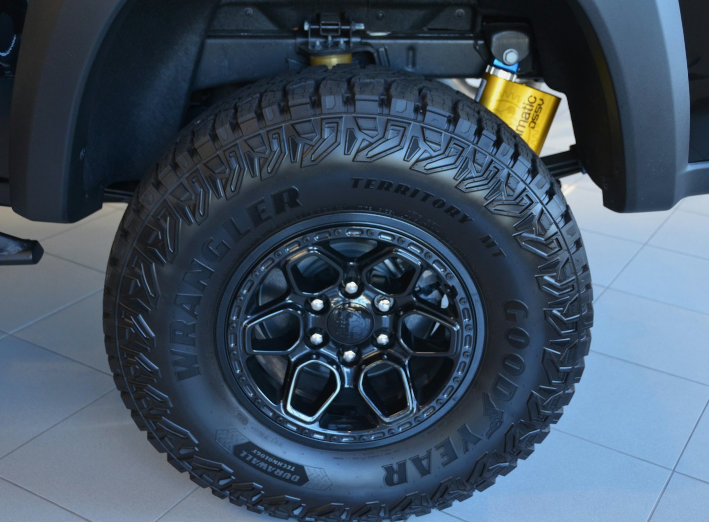 Rugged black off-road tire with a yellow shock absorber.